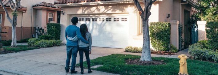 Couple Standing In Front of their House